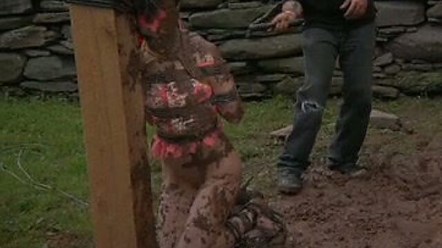 Messy brunette is tied up and covered with mud