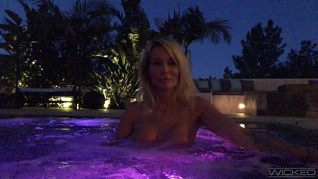 Topless Jessica Drake gives an interview in the pool